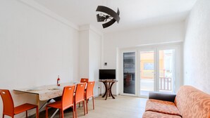 Un espace repas comprenant une table, des chaises et un téléviseur.