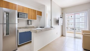 A modern kitchen with a built-in microwave, stainless steel refrigerator, and blue cabinets. - Beach Praia Grande Ubatuba (Ubatuba)