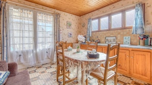 Una cocina con muebles de madera, una mesa de comedor y sillas.
