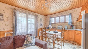 Una cocina acogedora con armarios de madera, una mesa de comedor y un sofá con cojín.