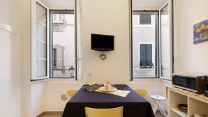 A dining area with a table, chairs, a television, and a microwave. - Apartment 'Smart Home Loano' with Wi-Fi and Air Conditioning (Loano)