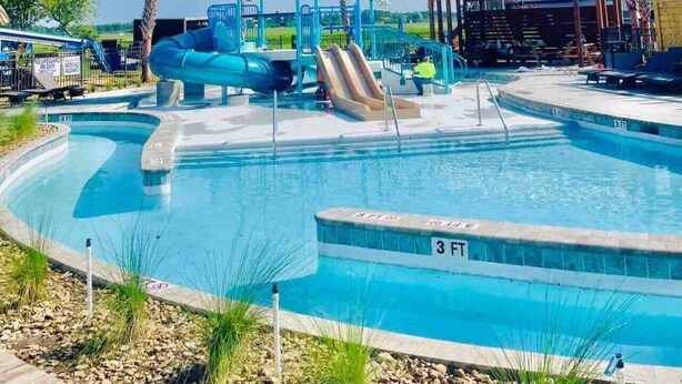 A swimming pool with a water slide and a covered seating area. - Vacation Cottage North Myrtle Beach #68 (North Myrtle Beach)