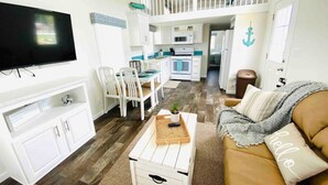 A compact living space with a kitchenette, a dining area, and a seating area with a sofa and chairs. - Vacation Cottage North Myrtle Beach #68 (North Myrtle Beach)