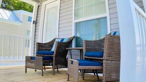 A covered porch with wicker furniture and a ceiling fan. - Vacation Cottage North Myrtle Beach #68 (North Myrtle Beach)