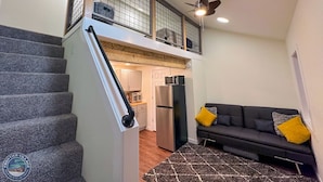 A staircase leading to an upper level with a kitchen area below.