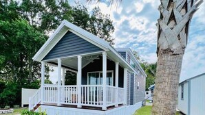 A two-story house with a covered porch and a small deck. - Vacation Cottage North Myrtle Beach #65 (North Myrtle Beach)