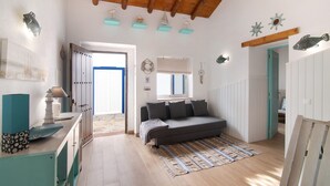 Een kamer met een houten plafond, een bank, een kamerkleed met een patroon en decoratieve muurkunst.