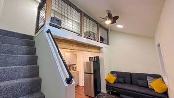 A staircase leading to an upper level with a kitchen area below.