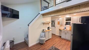 Una cocina moderna con comedor, escalera y sala de estar.