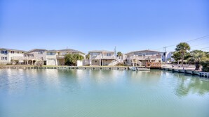 Une propriété située au bord de l’eau, comprenant plusieurs bâtiments à deux étages, un quai et un petit bateau.