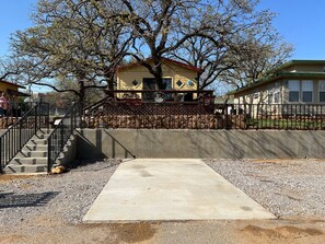 A house with a concrete patio, a staircase, and a fenced area. - Easy Rider Cabin -Boat/Trailer prkg, Pet ok w/fee (Medicine Park)