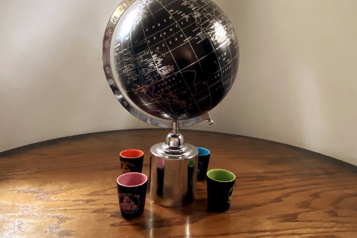 Un globo sobre una mesa de madera, rodeado de cuatro tazas.