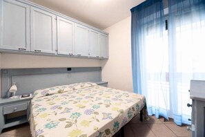 Ein Schlafzimmer mit Bett, Nachttisch und Kleiderschrank.