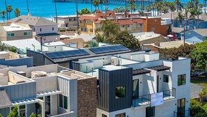 A residential area with modern houses, a pier, and a clear blue sky. - Rooftop Ocean-View Home, Private Parking, Near Beach (Oceanside)