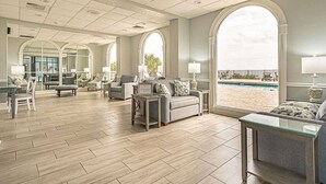 A spacious living area with a pool view, large windows, and a modern interior design. - ⛱ DIRECT OCEANFRONT⛱ PENTHOUSE VIEW! ALL NEW LARGE BALCONY! ALL NEW RENOVATION! (Myrtle Beach)