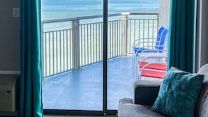A balcony with a view of the ocean, a red and blue chair, and a teal cushion. - ⛱ DIRECT OCEANFRONT⛱ PENTHOUSE VIEW! ALL NEW LARGE BALCONY! ALL NEW RENOVATION! (Myrtle Beach)