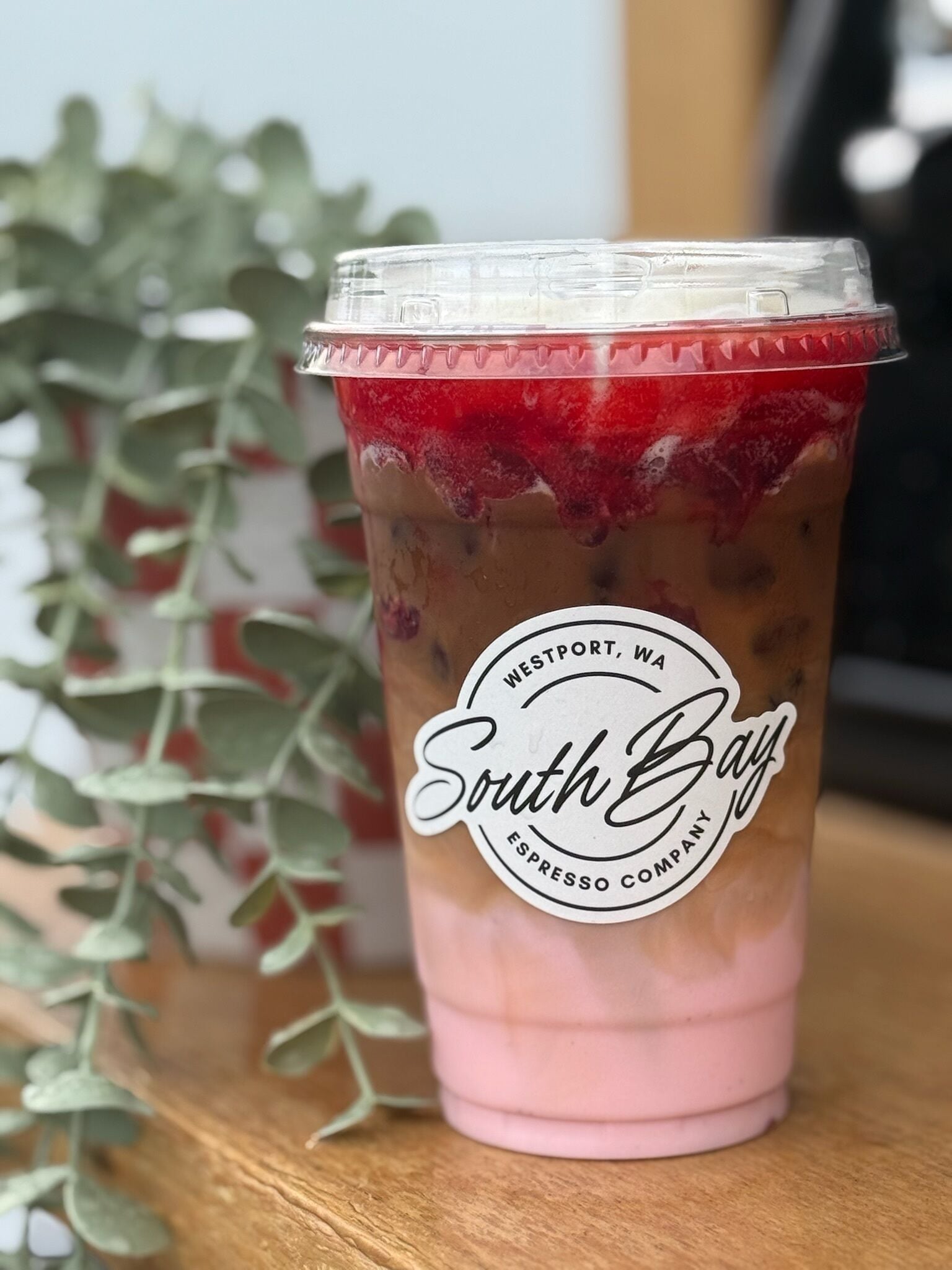 A cup of iced coffee with a label reading "Westport, WA South Bay Espresso Company."