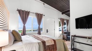 A modern hotel room with a large bed, a desk, and a TV. - South Bay Inn  (Westport)