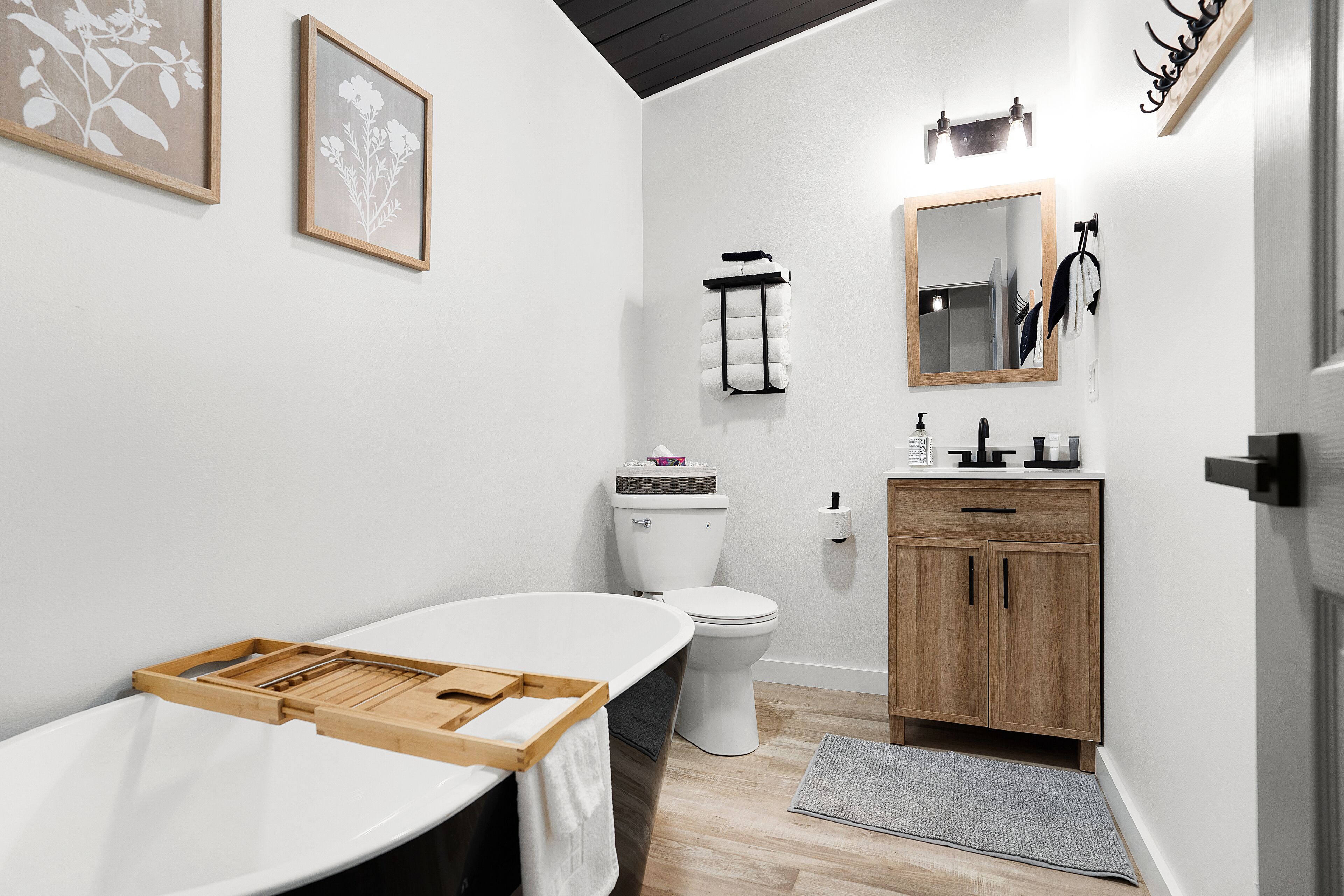 Une salle de bain moderne avec une baignoire, des toilettes et un meuble-lavabo en bois.