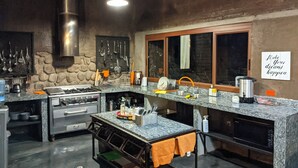 Una cocina moderna con encimeras de granito, electrodomésticos de acero inoxidable y salpicadero de piedra.