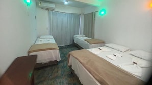 Habitación de hotel con dos camas individuales, un escritorio y una silla.