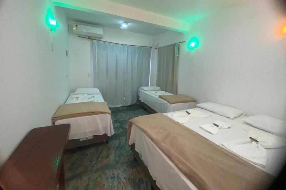 A hotel room with two single beds, a desk, and a chair.