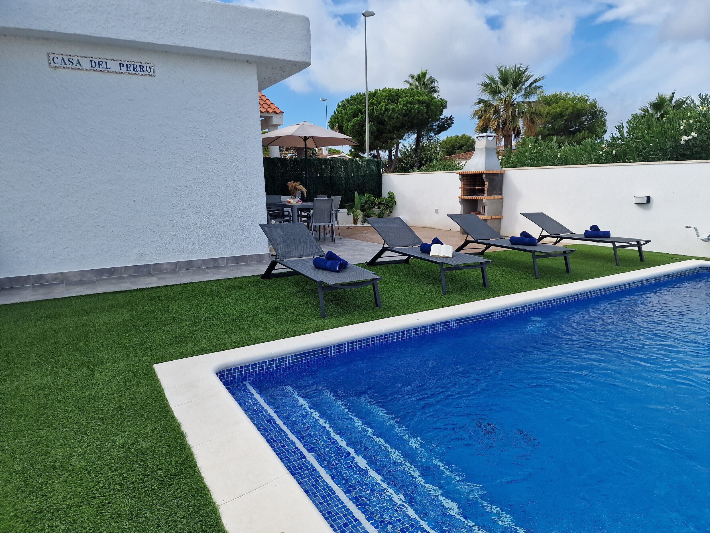 A swimming pool with lounge chairs and a patio area.