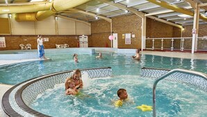 Una piscina interior amb diverses pistes i una zona de banyera hidromassatge.