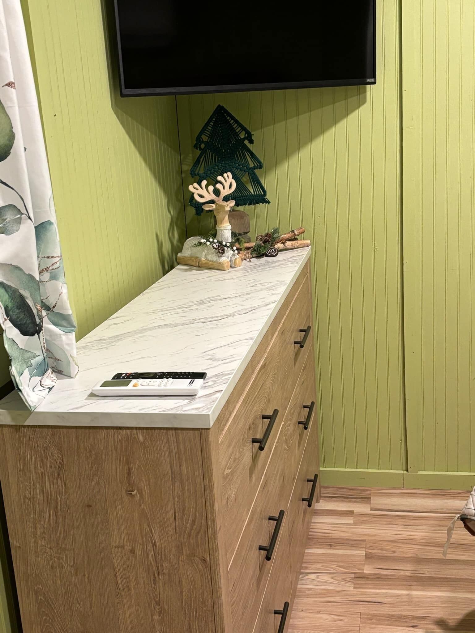 A wooden dresser with drawers and a marble countertop.