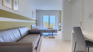 Une chambre d’hôtel moderne dotée d’un canapé, d’un coin repas et d’un balcon avec vue.