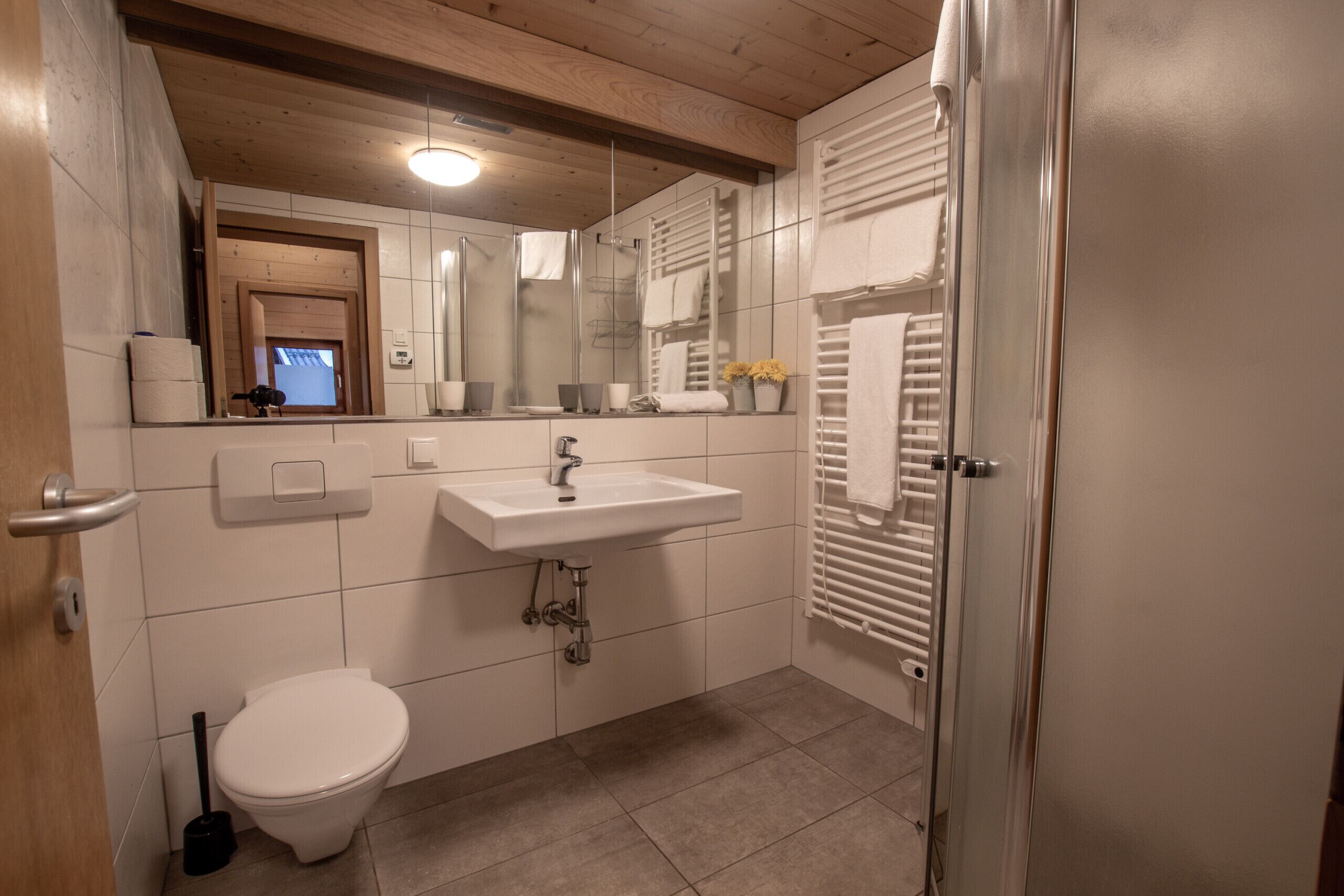A modern bathroom with a sink, toilet, and a mirror.
