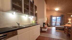 A modern kitchen with a dishwasher, a sink, and a window overlooking a scenic landscape. - Lake and Mountain View (Zell am See)