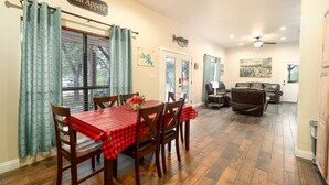 A dining area with a table set for four, wooden chairs, and a red checkered tablecloth.