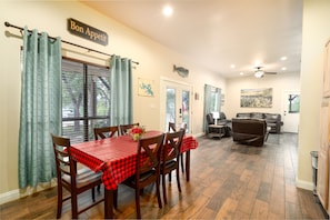 Relax in this inviting living area with a dining table for four, a comfortable sofa, and a television.