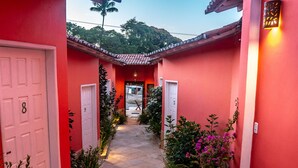 A narrow corridor with red walls and white doors numbered 8 and 9. - Pousada Vento Terral (Tibau do Sul)