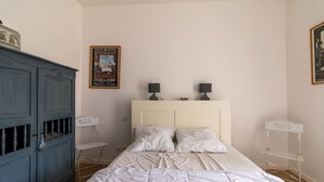 A bedroom with a bed, a dresser, two bedside tables, and a poster on the wall. - Apartment near beaches in Fréhel | 4 guests | Ref 359 (FREHEL)