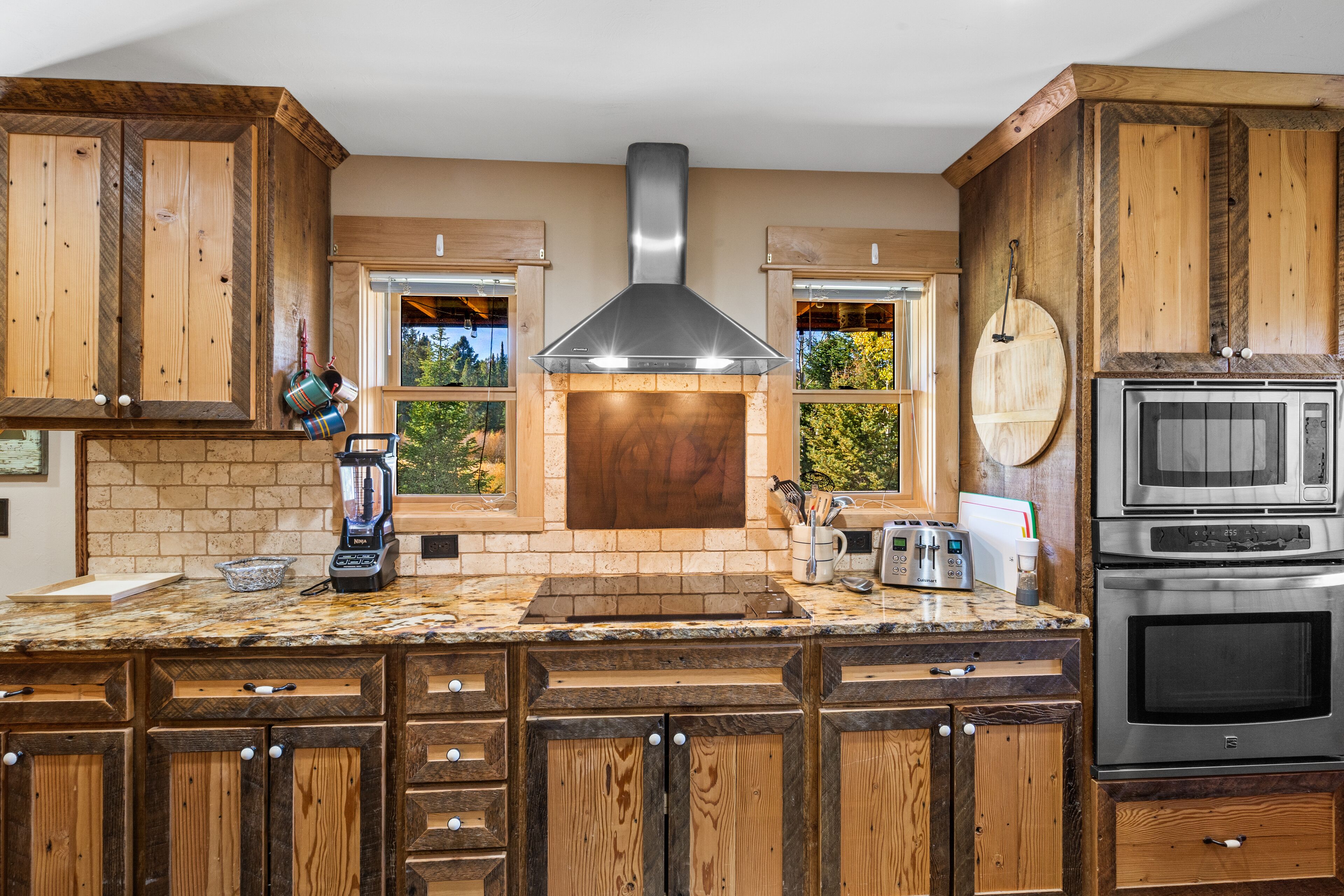 A kitchen with wooden cabinets, a built-in oven, a microwave, and a brick backsplash.