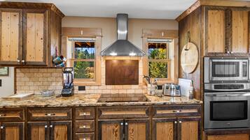 A kitchen with wooden cabinets, a built-in oven, a microwave, and a brick backsplash.