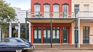 Un edificio rosso con un balcone, porte nere e un'insegna che recita 'The Continental Cook'.