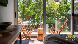 Una habitación moderna con un amplio ventanal, muebles de madera y vistas a zonas verdes.