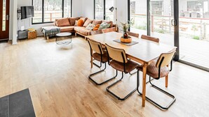 Un salon spacieux avec une grande table à manger, un canapé et un téléviseur.