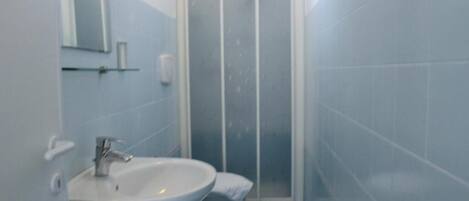 Un baño con lavamanos, espejo y ducha.