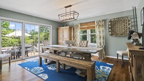 A dining area with a wooden table, bench, and chairs, a chandelier, and a view of the outdoors through large windows. - Beautifully decorated, 15-20 min to downtown Cincy. (Cincinnati)