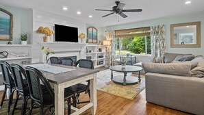 A modern living room with a fireplace, dining area, and a large window with curtains. - Beautifully decorated, 15-20 min to downtown Cincy. (Cincinnati)