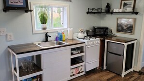 A compact kitchen with a sink, stove, microwave, and small refrigerator. - 10 minute walk to restaurants & trails - Convenient Location - #4 Slumber Village (Anchorage)