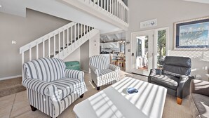 A spacious living area with a high ceiling, a staircase, and a view of the outdoors. - 3BR/2BA Cottage! Close to beach! Golf Course Views! Amenity access available! (Seabrook Island)