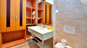 Une salle de bain avec des meubles en bois, un lavabo, un miroir et un mur en marbre.