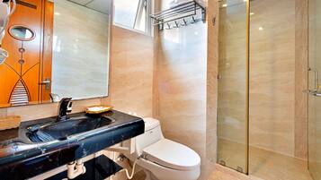 Ein modernes Badezimmer mit einem schwarzen Marmorwaschbecken, einer weißen Toilette und einer Duschkabine aus Glas.