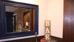 Ein Badezimmer mit einem großen Spiegel, einem Waschbecken und einem Holzschild mit der Aufschrift 'BAR'.