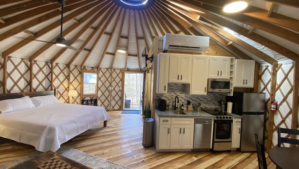 Ein geräumiges Zimmer mit einem Bett, einem Schreibtisch und einer Küchenzeile.